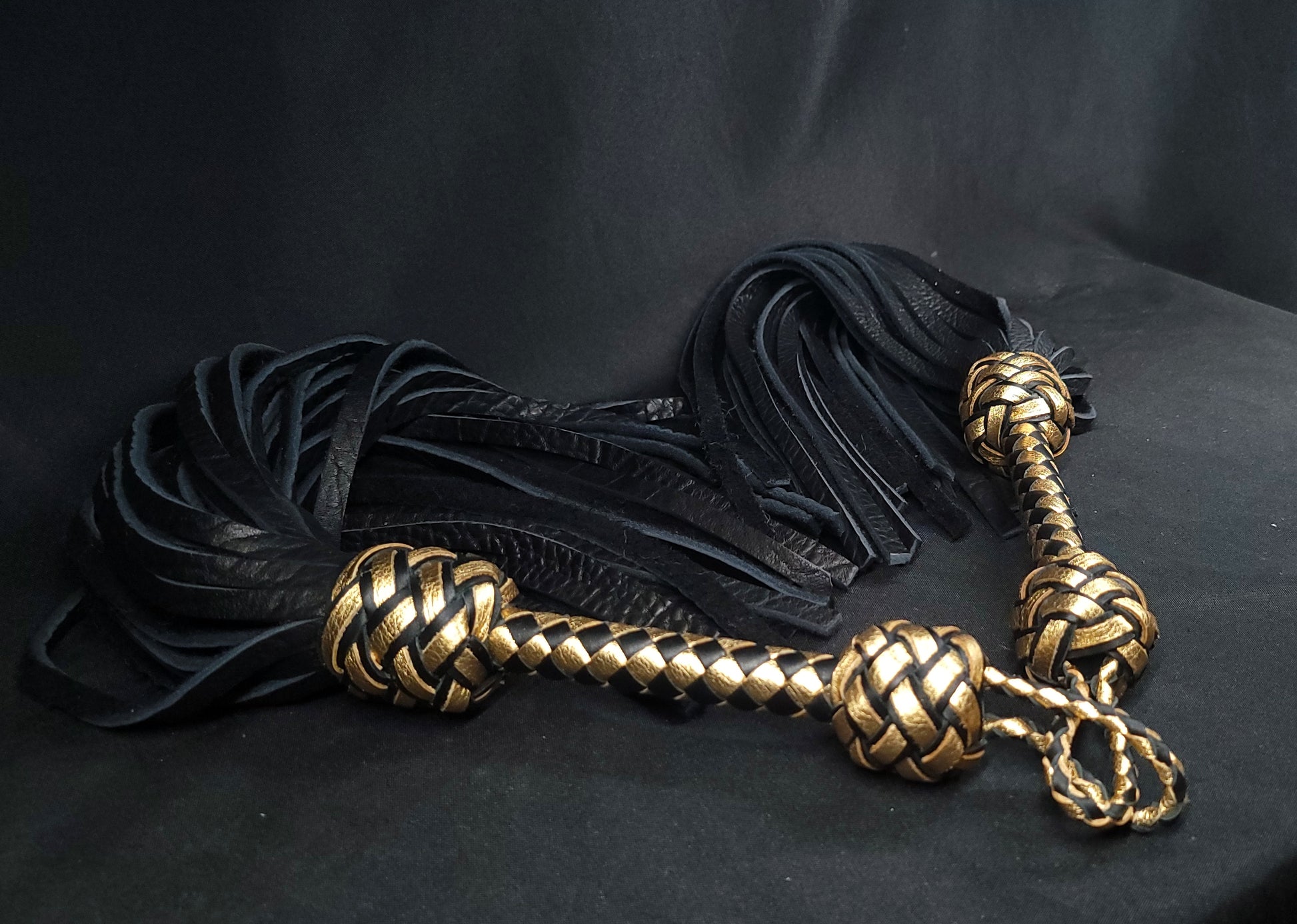 Two Black and Gold Bison Leather BDSM Floggers in a heart