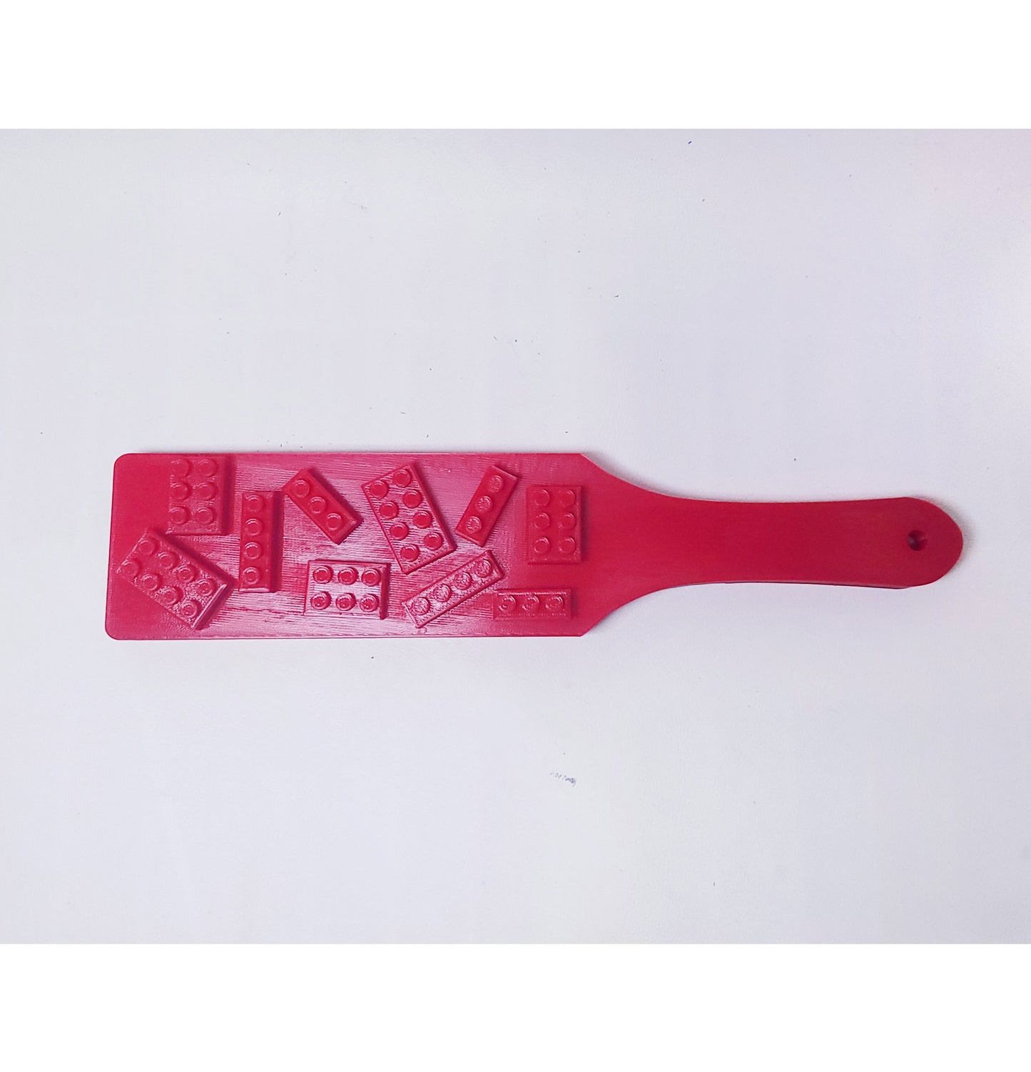 red plastic paddle with lego like bricks