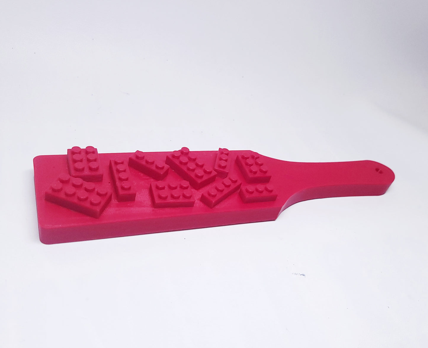 red plastic paddle with lego like bricks