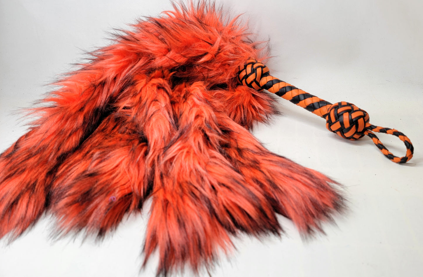Orange fluffinator weighted fur flogger for bdsm