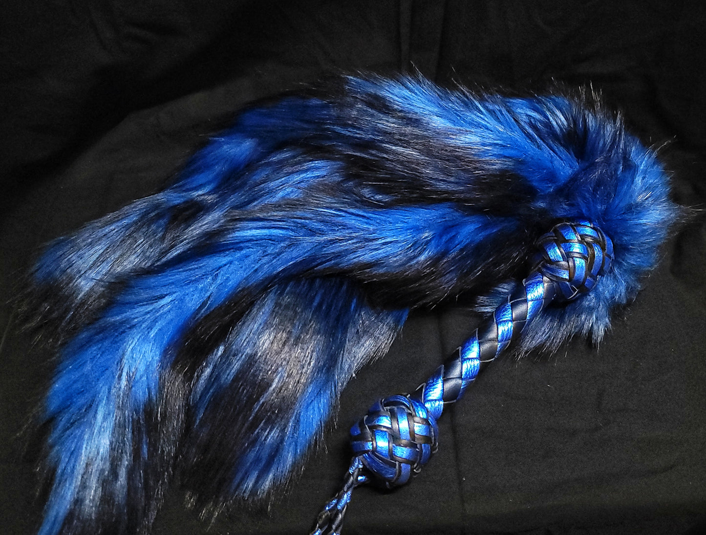 A blue Fluffinator. A weighted fur flogger for kink and bdsm.