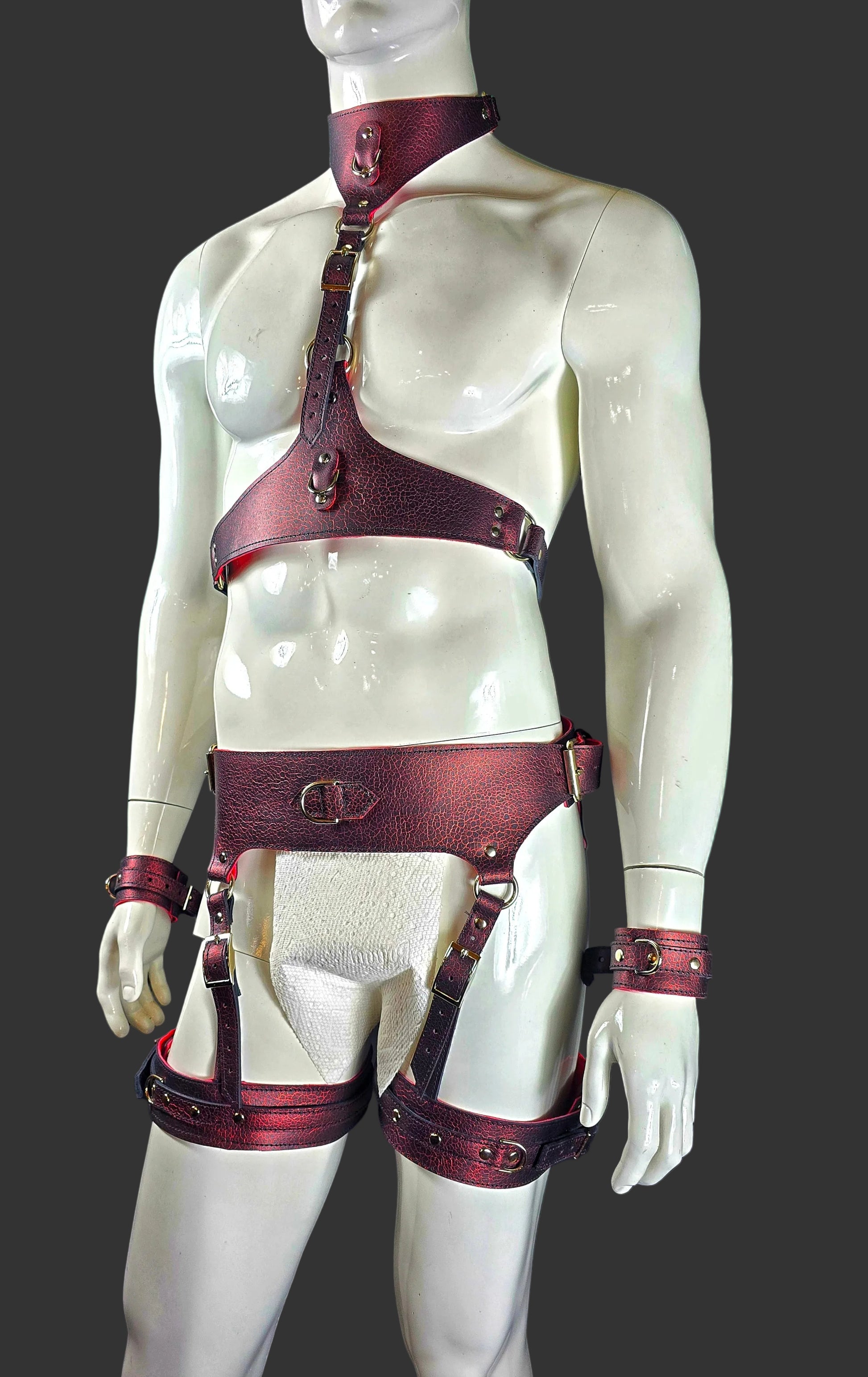 Mannequin wearing a red leather harness against a black background