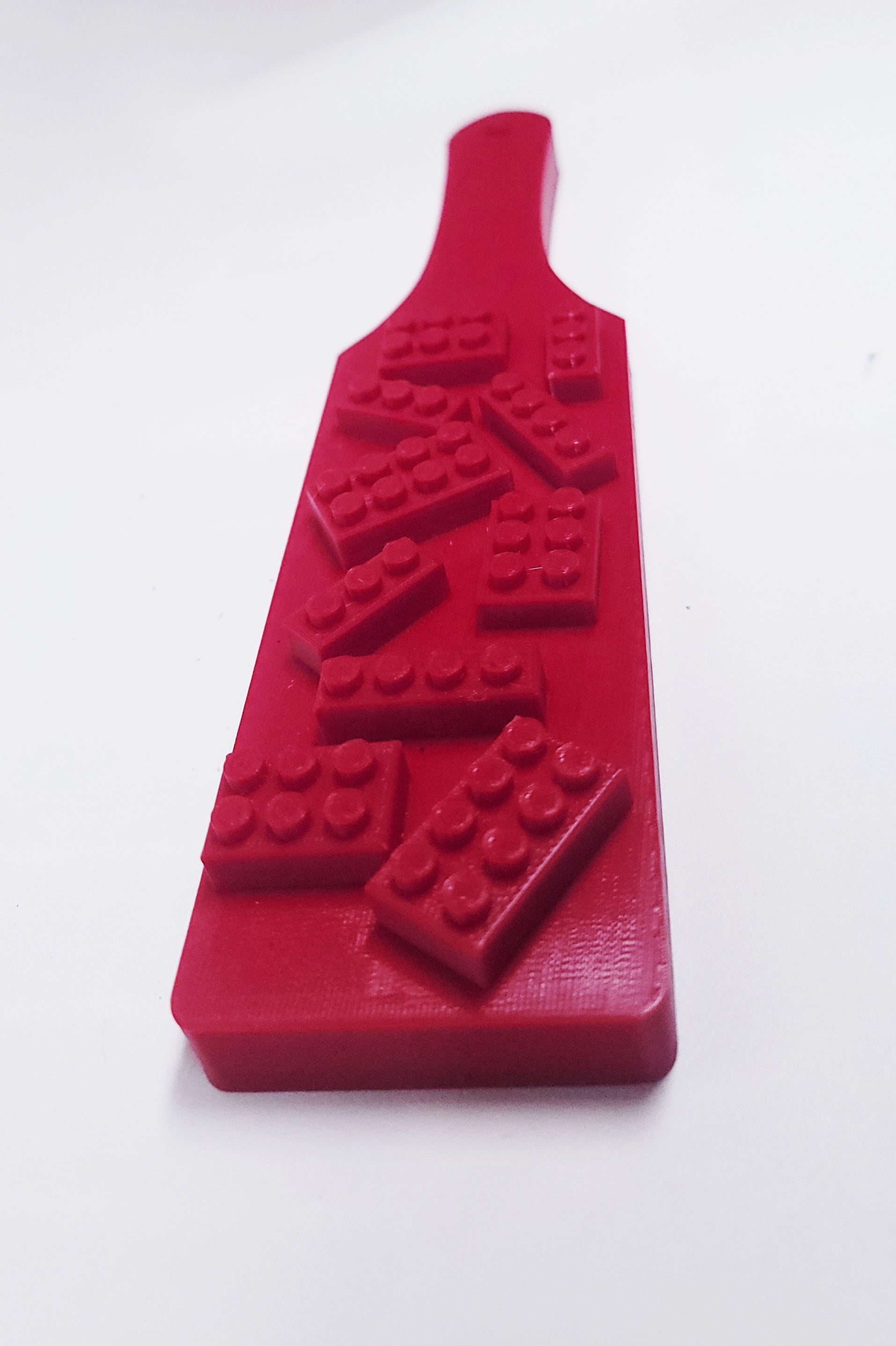 red plastic paddle with lego like bricks