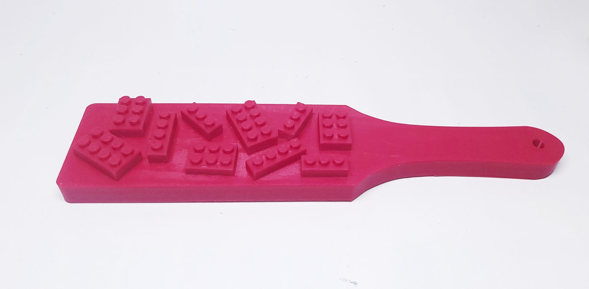 red plastic paddle with lego like bricks